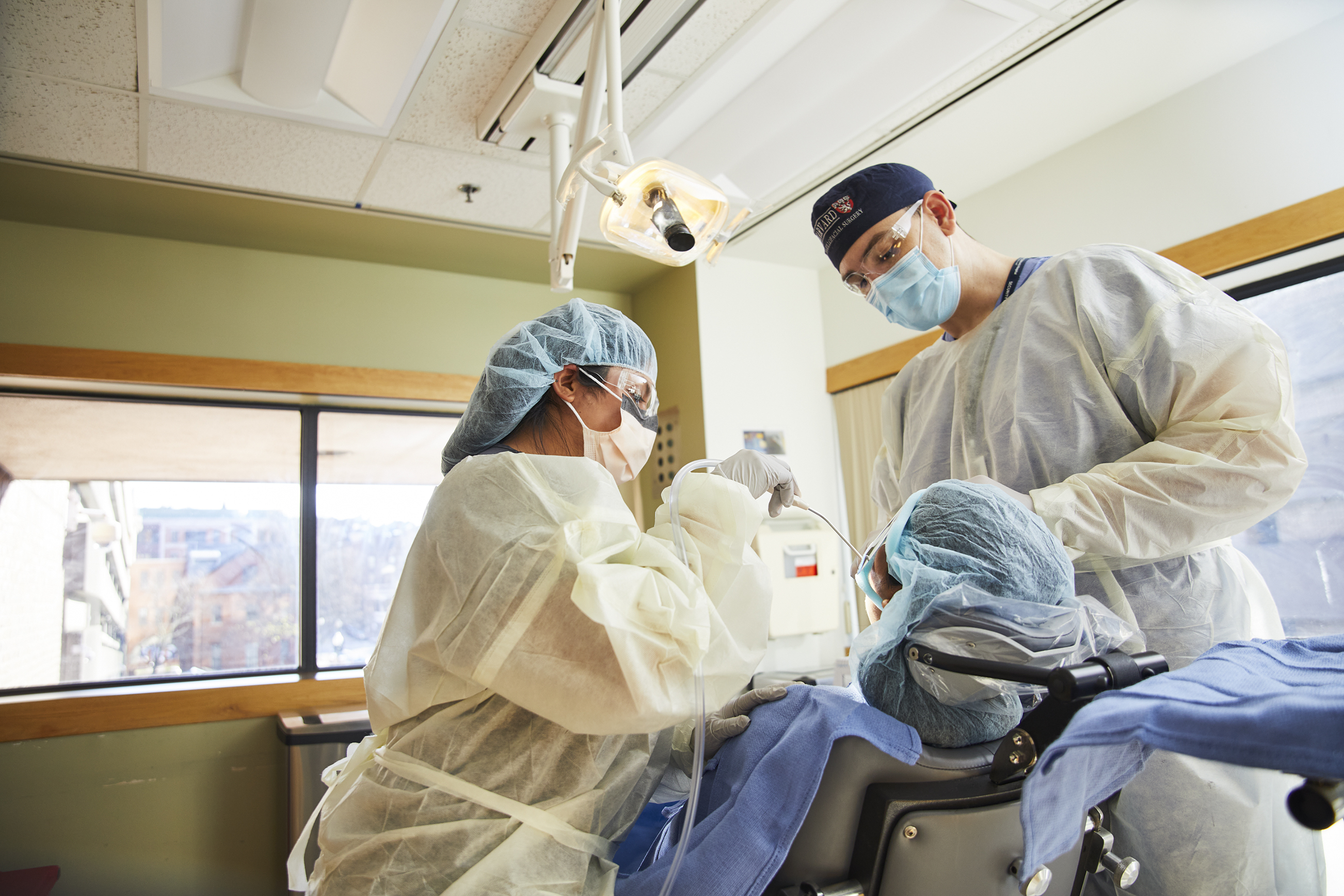 Two oral surgeons treating a patient Two oral surgeons treating a patient